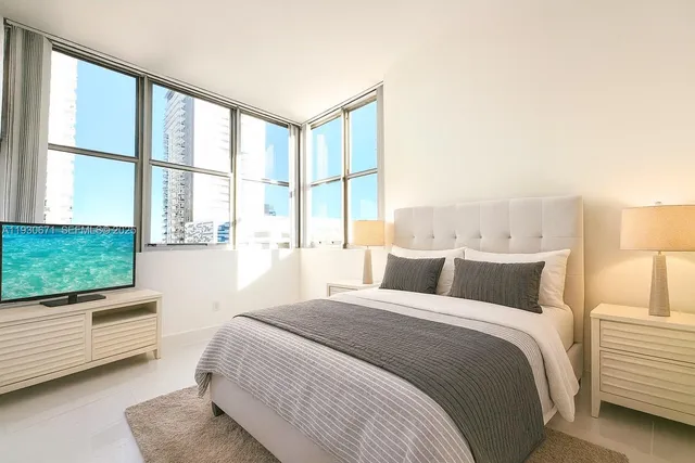 a bedroom with a large bed and a large window