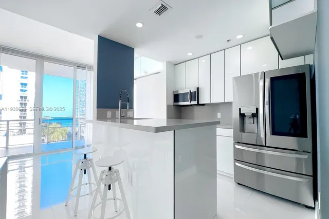 a kitchen with stainless steel appliances a refrigerator and a stove top oven