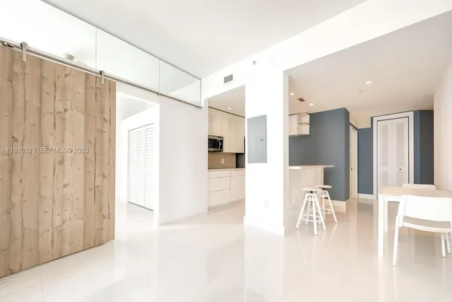 a kitchen with stainless steel appliances kitchen island granite countertop a refrigerator and cabinets