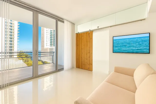 a living room with a large window and a ceiling fan