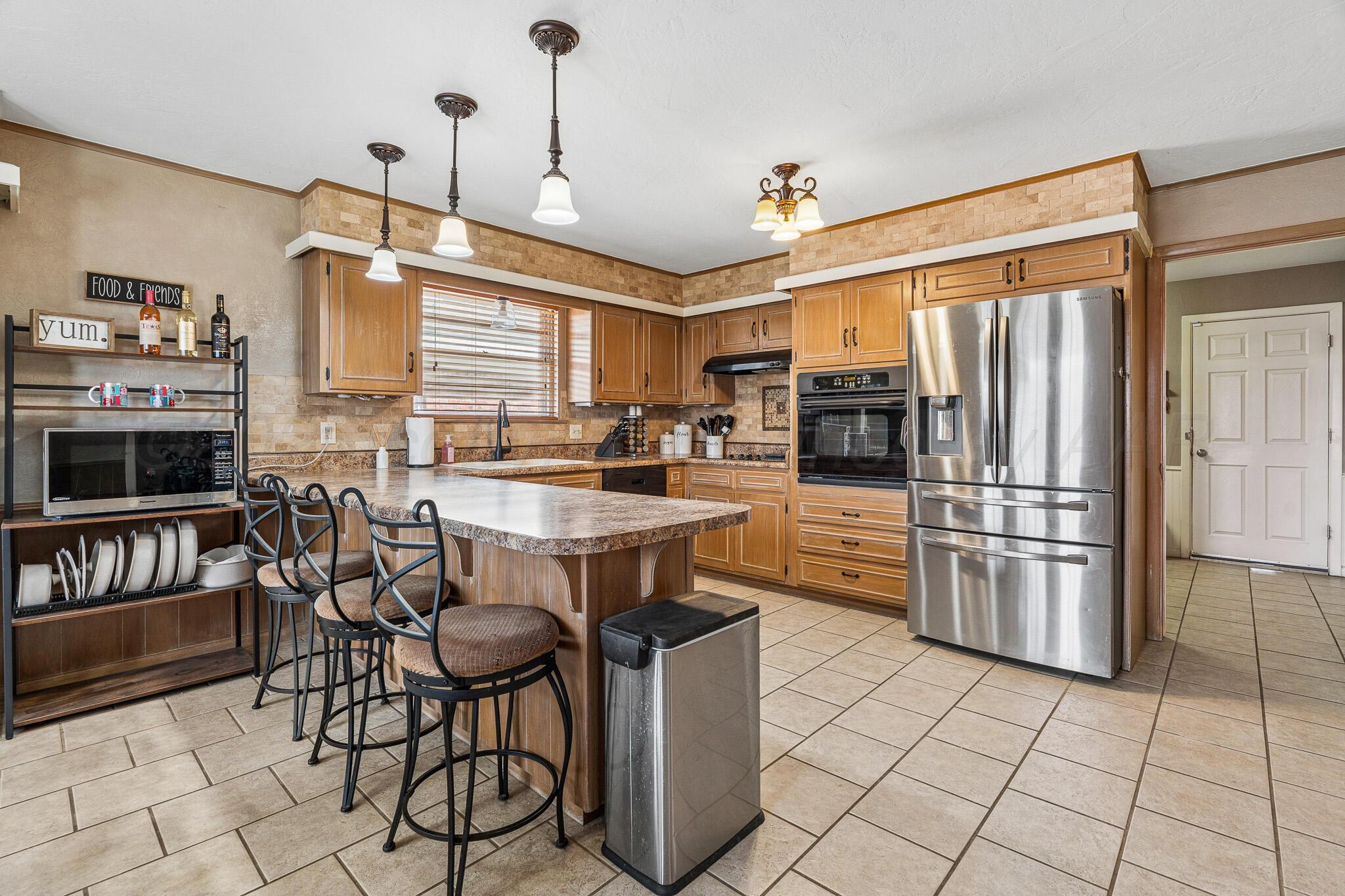 3424 Wayne Street Amarillo, TX 79109 - Photo 13 of 33 a kitchen with stainless steel appliances granite countertop a stove and a refrigerator