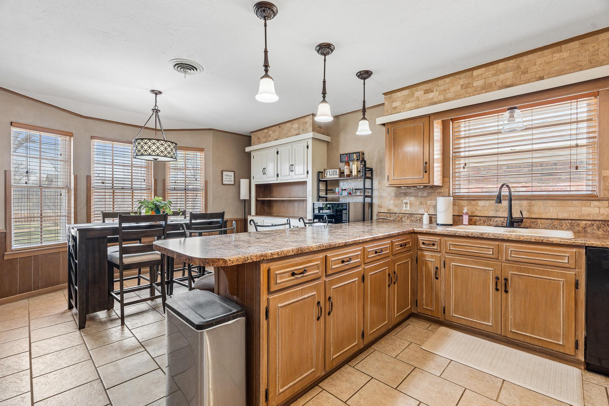 3424 Wayne Street Amarillo, TX 79109 - Photo 14 of 33 a kitchen with cabinets a sink dining table and chairs