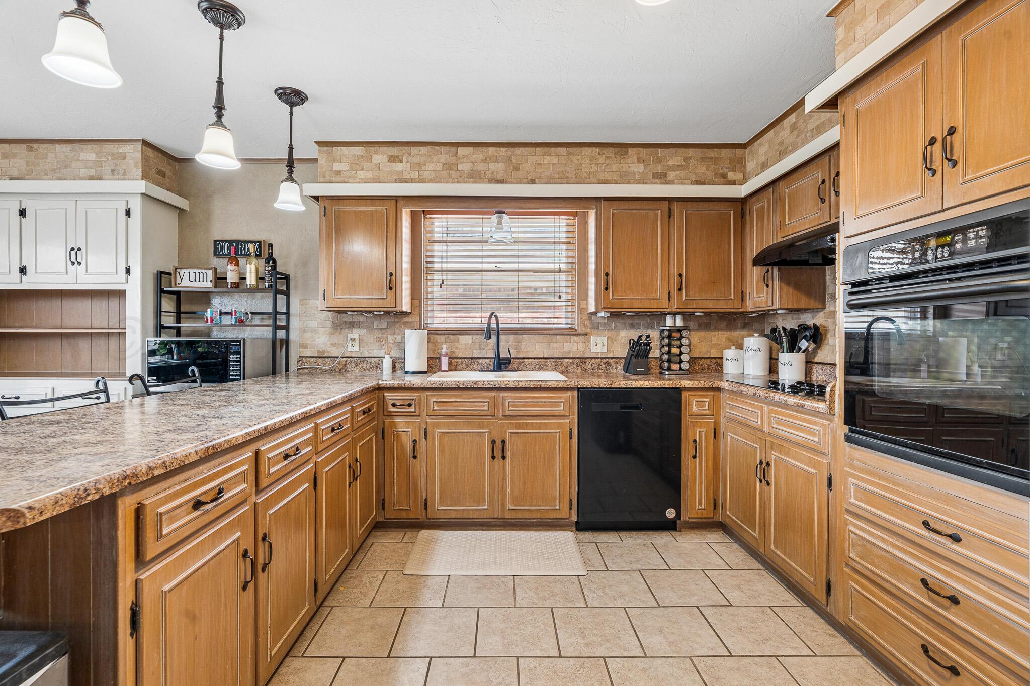 3424 Wayne Street Amarillo, TX 79109 - Photo 16 of 33 a kitchen with stainless steel appliances granite countertop a sink and cabinets