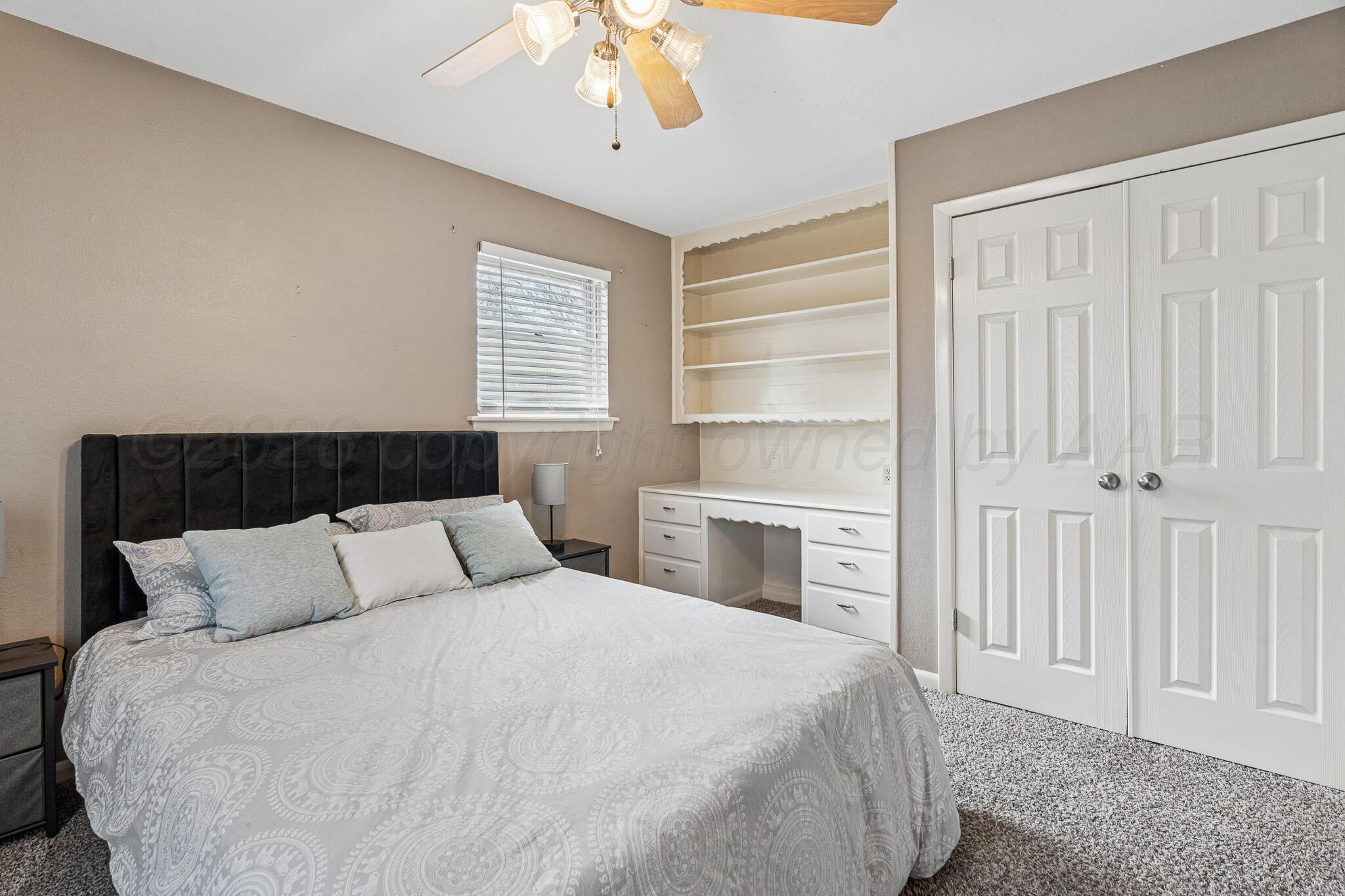 3424 Wayne Street Amarillo, TX 79109 - Photo 21 of 33 a bedroom with a large bed and a chandelier