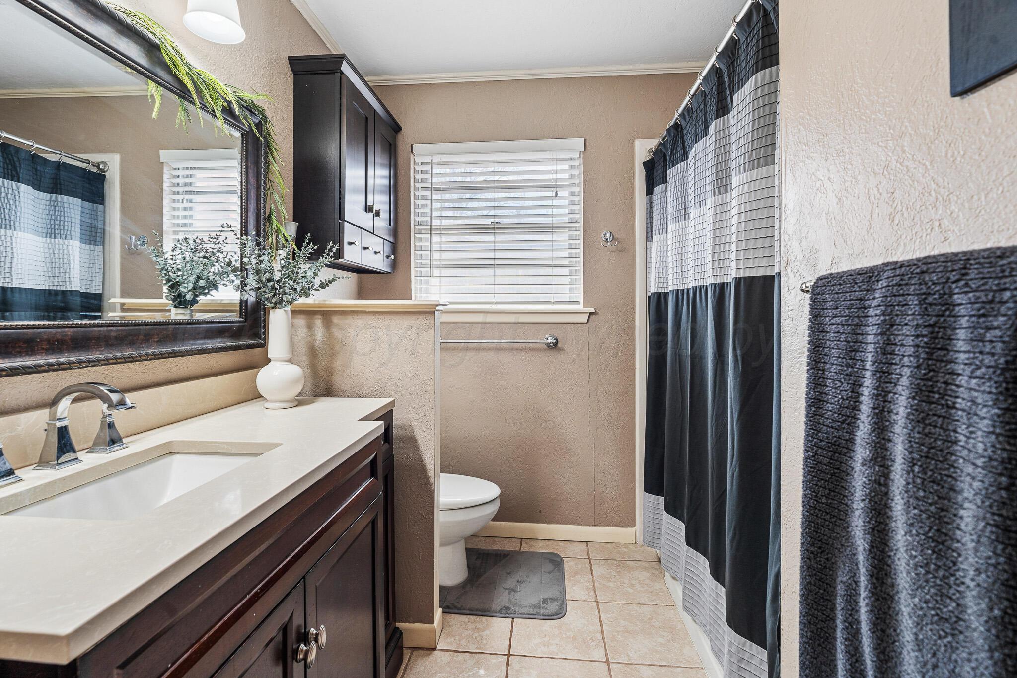 3424 Wayne Street Amarillo, TX 79109 - Photo 22 of 33 a bathroom with a sink and a mirror