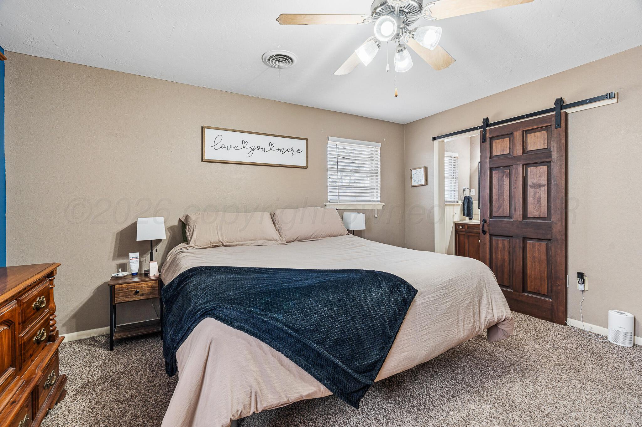 3424 Wayne Street Amarillo, TX 79109 - Photo 26 of 33 a bedroom with a large bed and a chandelier