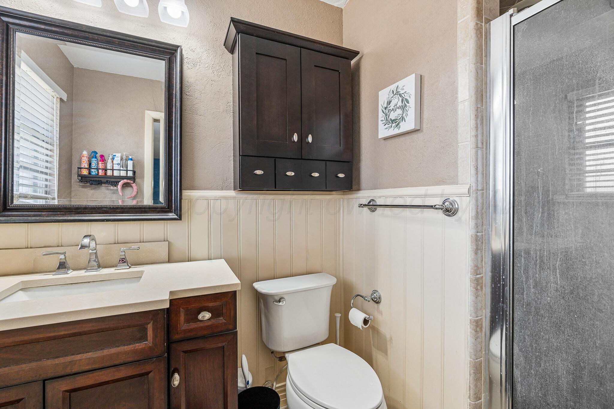 3424 Wayne Street Amarillo, TX 79109 - Photo 28 of 33 a bathroom with a toilet a sink and mirror