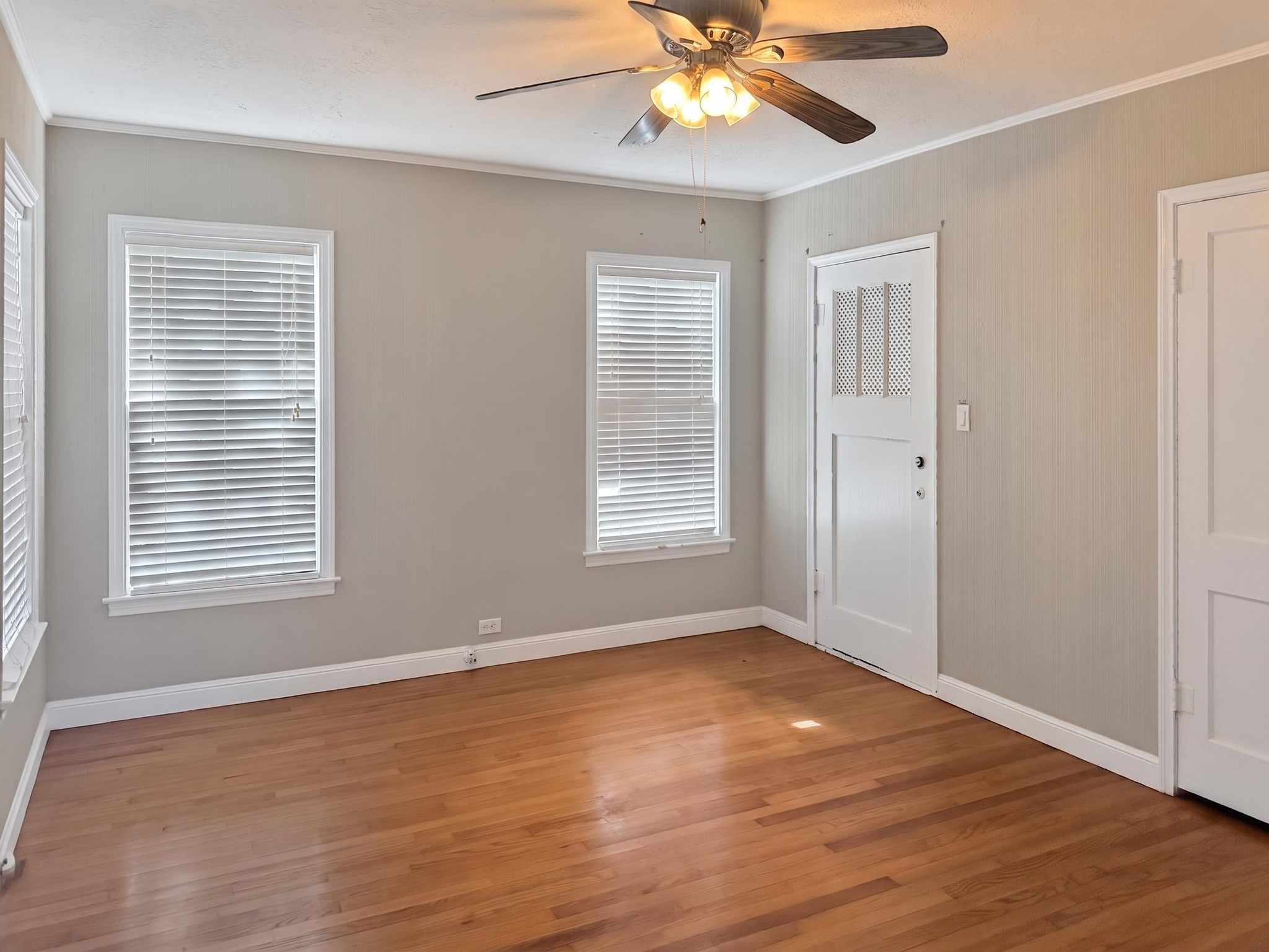 2313 Avenue L Rosenberg, TX 77471 - Photo 16 of 31 Alternate view of the spacious bedroom showcasing hardwood floors, multiple windows, and abundant natural light.