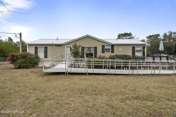 a view of a house with a wooden deck and a yard