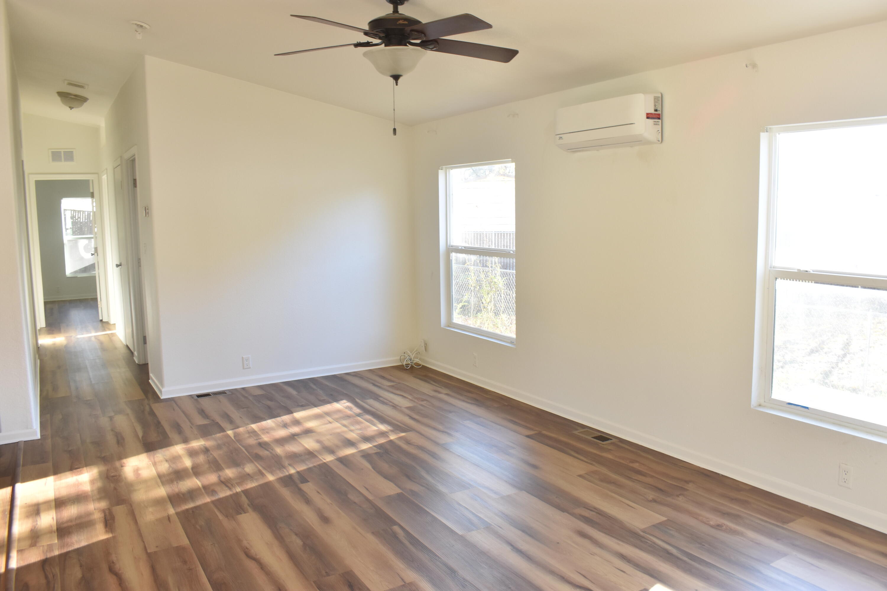 12125 Lake Boulevard Redding, CA 96003 - Photo 2 of 24 an empty room with wooden floor fan and windows