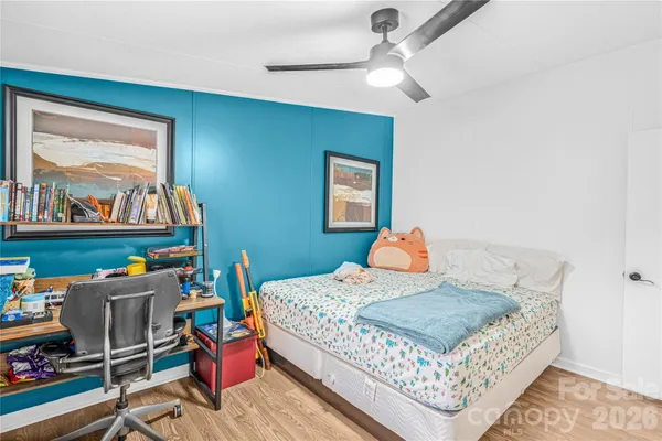 a bedroom with a bed a dresser and painting