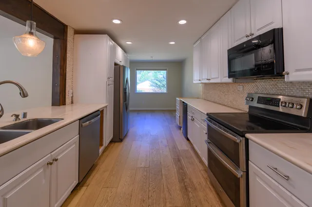 a kitchen with a sink a center island and furniture