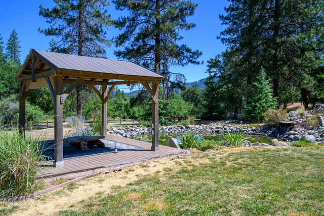 a view of house with yard outdoor seating and covered with trees