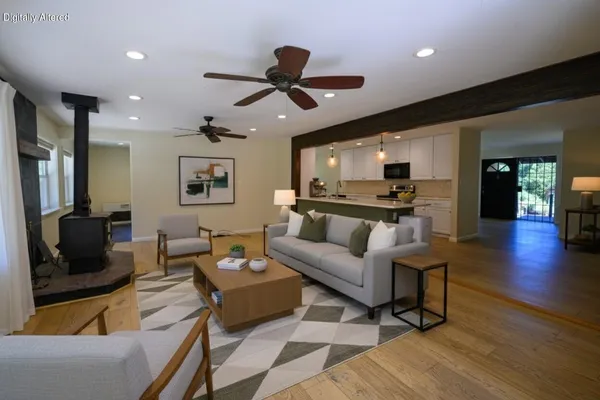 a kitchen with stainless steel appliances a sink dishwasher a stove top oven a refrigerator with wooden floor