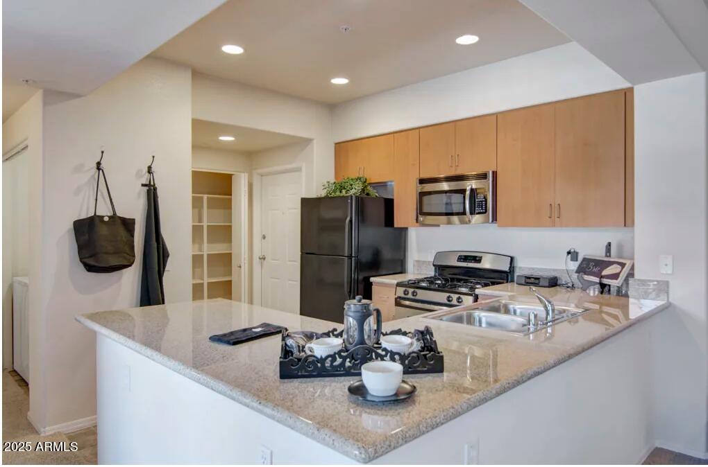 3825 West Anthem Way, Unit A1 Anthem, AZ 85086 - Photo 3 of 11 a kitchen with stainless steel appliances granite countertop a sink refrigerator and microwave