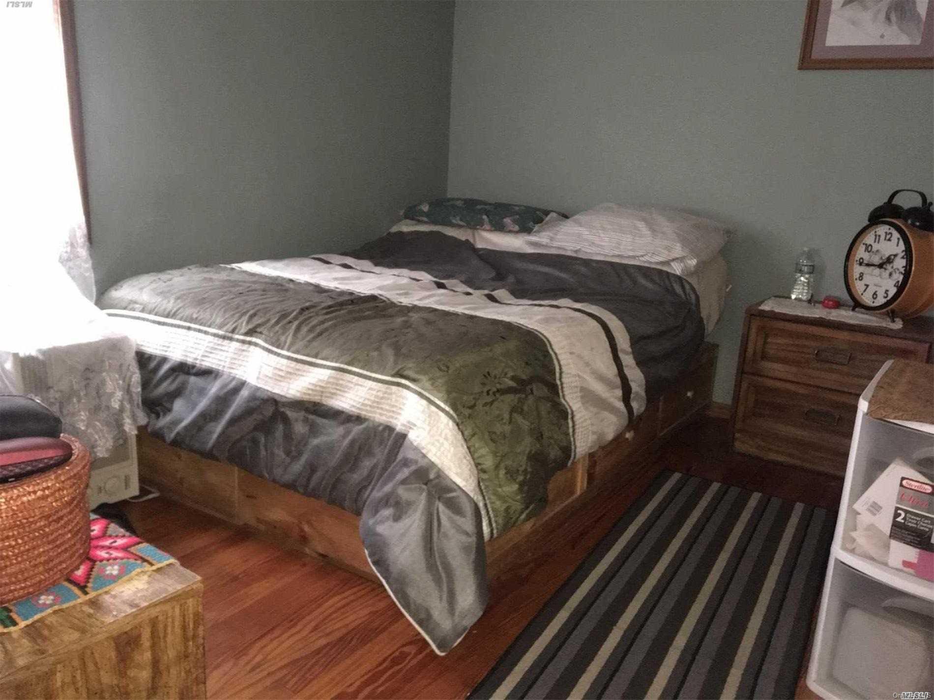 60-13 59th Road Queens, NY 11378 - Photo 18 of 20 a bed sitting in a bedroom next to a window