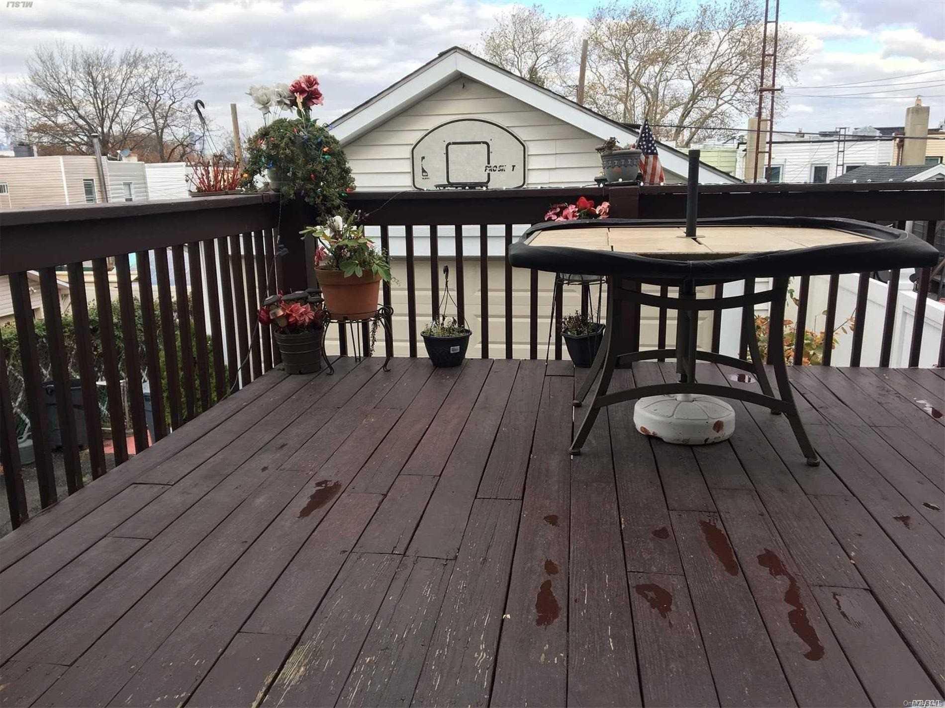 60-13 59th Road Queens, NY 11378 - Photo 7 of 20 a view of deck with wooden floor and outdoor seating