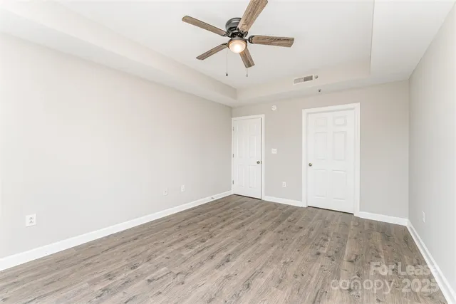 an empty room with a window and a ceiling fan