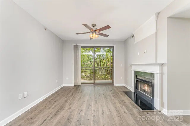 an empty room with windows fireplace and a sink