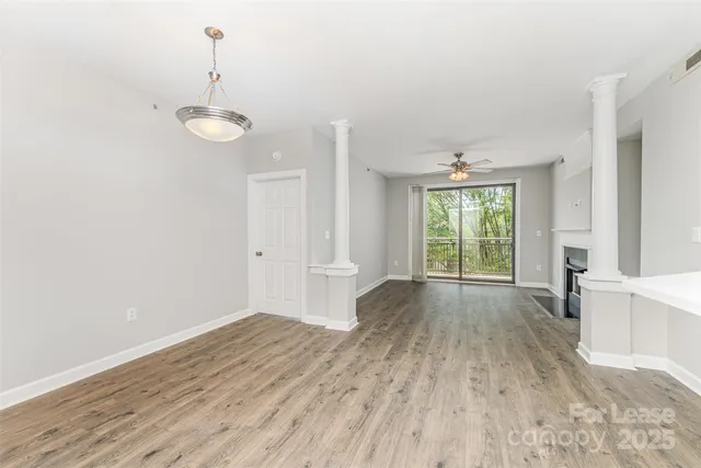 a view of empty room with wooden floor and window