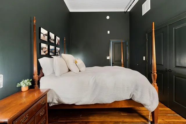 a bedroom with a bed and wooden floor