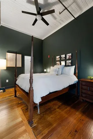 a bedroom with a bed and wooden floor