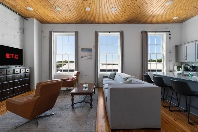 a living room with furniture a flat screen tv and a window