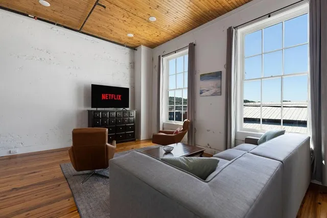 a living room with furniture a flat screen tv and a fireplace