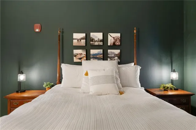 a bed sitting in a bedroom next to a lamp