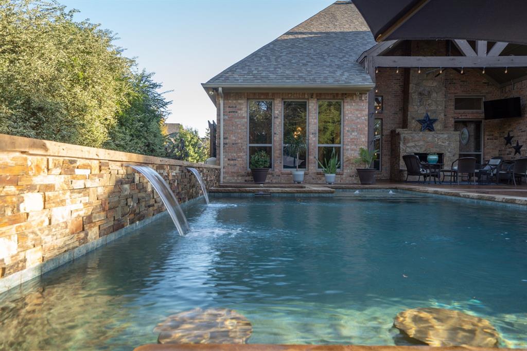 3328 Clubview Drive Denton, TX 76226 - Photo 31 of 40 This backyard pool is enhanced by a cascading waterfall, perfect for both entertaining and unwinding.