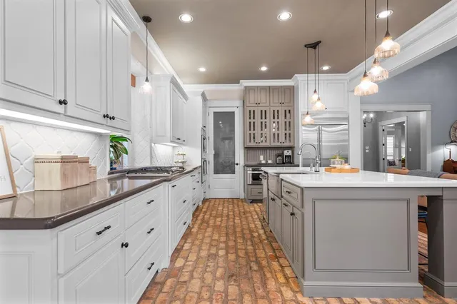 a large kitchen with stainless steel appliances and white cabinets