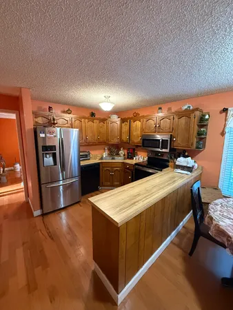 a kitchen with stainless steel appliances kitchen island sink stove and refrigerator