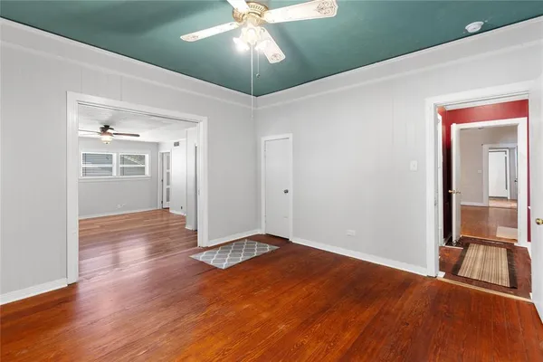 an empty room with an entryway and fan