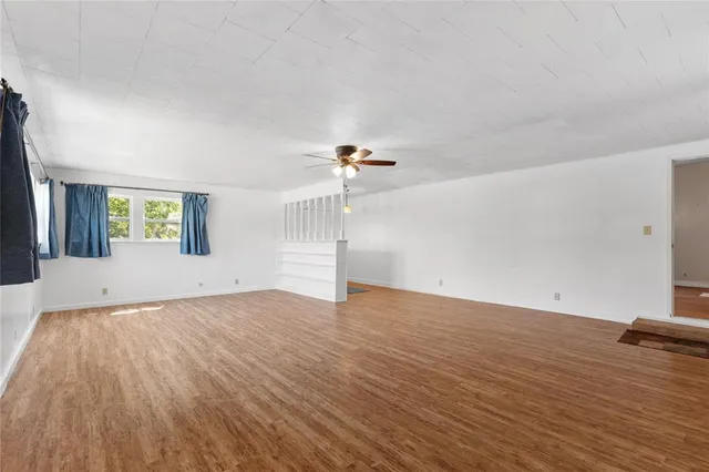 a view of empty room with wooden floor and windows