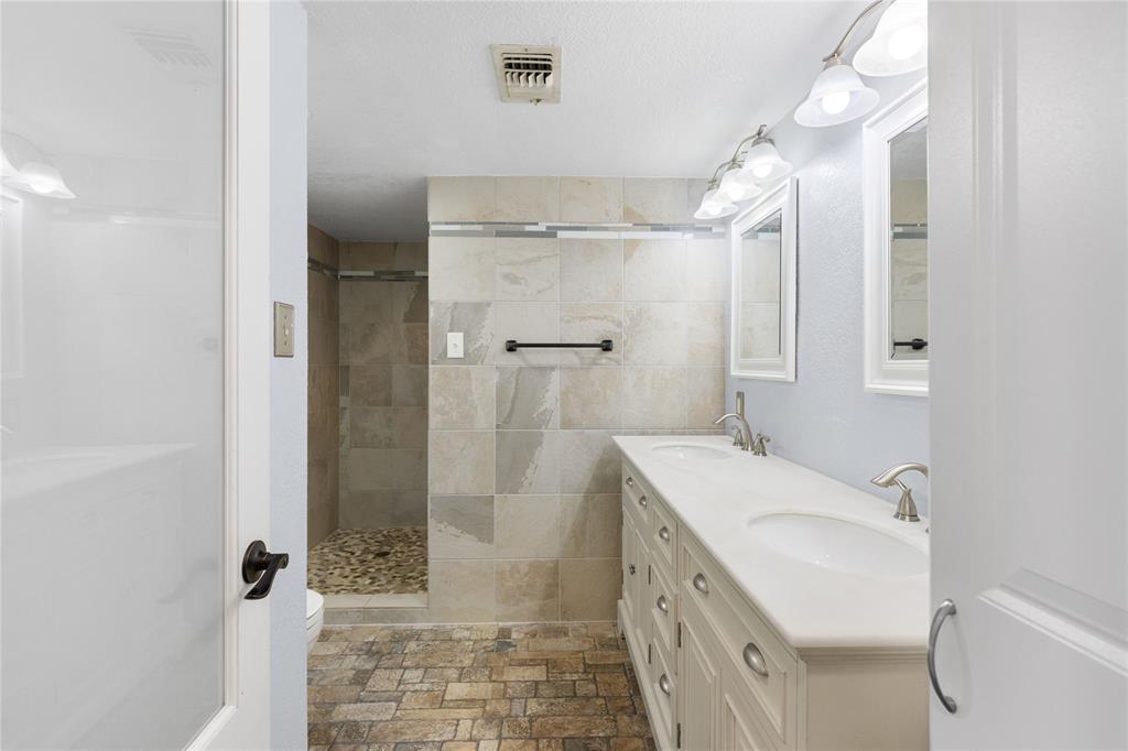 1005 Jernigan Street Commerce, TX 75428 - Photo 16 of 40 a bathroom with a sink a toilet and shower