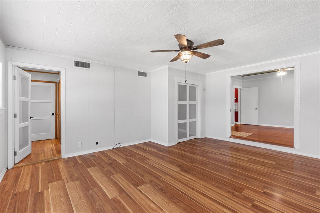 1005 Jernigan Street Commerce, TX 75428 - Photo 21 of 40 a bedroom with a bed and a chandelier