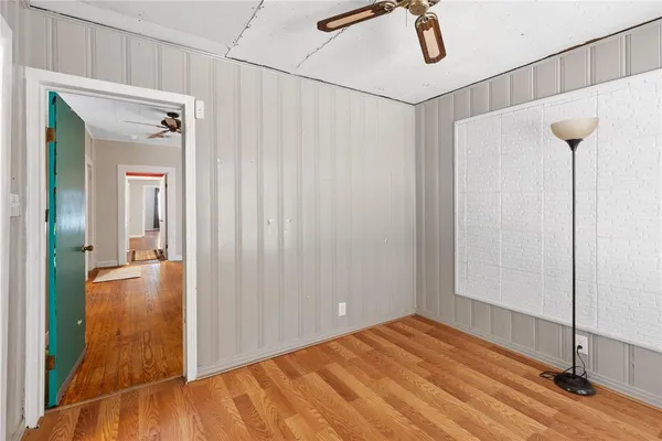 a view of an empty room with a window and wooden floor