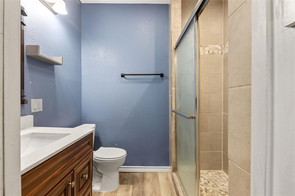 1005 Jernigan Street Commerce, TX 75428 - Photo 28 of 40 a bathroom with a sink a toilet and shower