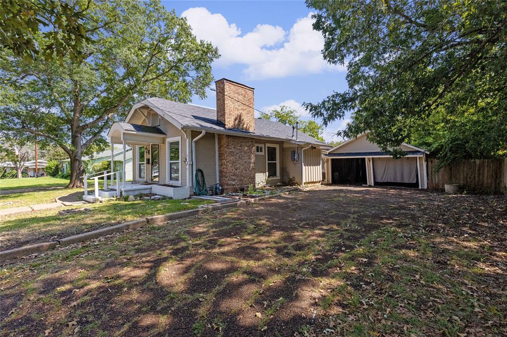 1005 Jernigan Street Commerce, TX 75428 - Photo 3 of 40 a front view of a house with a garden