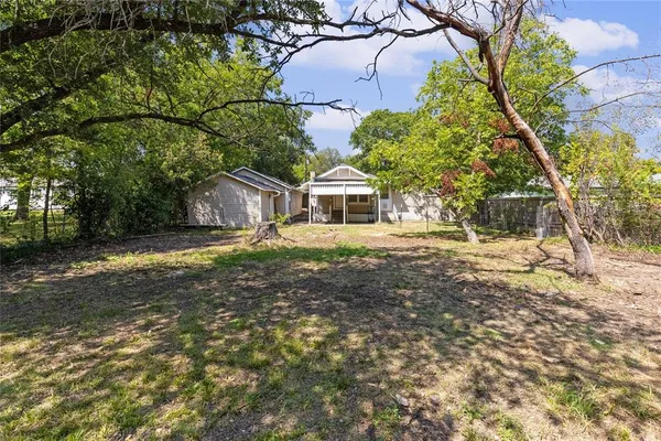 a view of a house with a backyard and a patio area with furniture