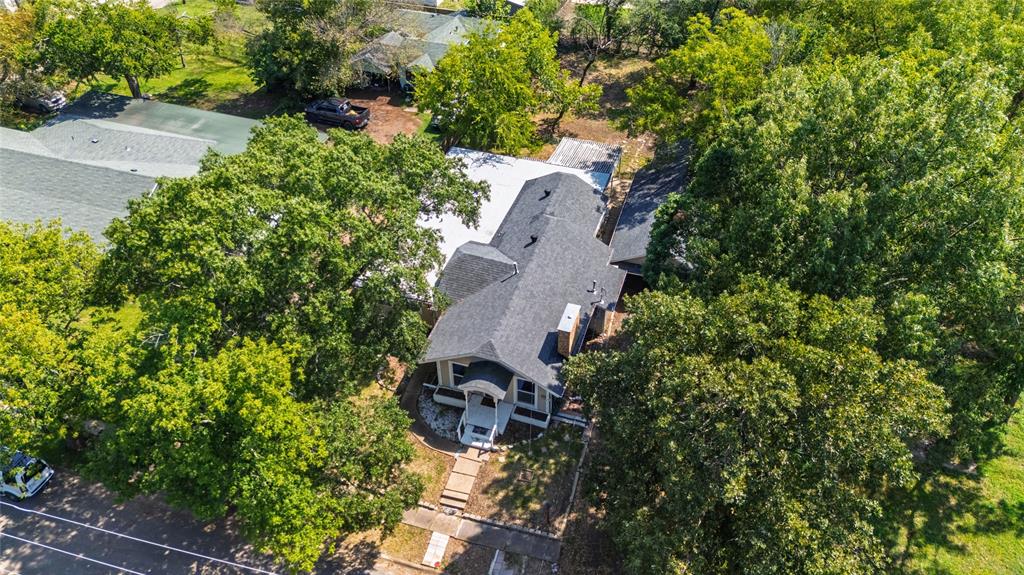 1005 Jernigan Street Commerce, TX 75428 - Photo 32 of 40 an aerial view of a house with a yard and covered with trees