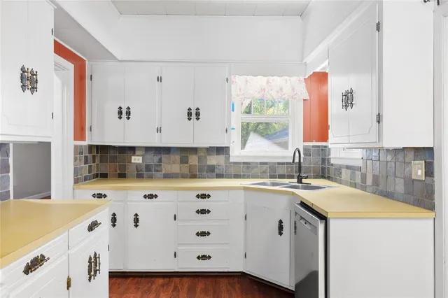 a kitchen with granite countertop a sink a stove and cabinets