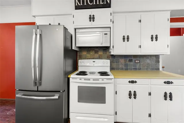 a kitchen with white cabinets and white appliances