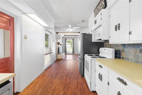 a kitchen with a stove a refrigerator and a stove with wooden floor