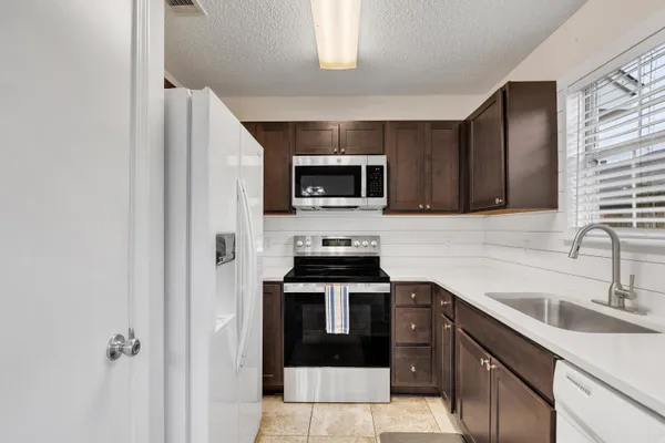 a kitchen with a sink stove and microwave