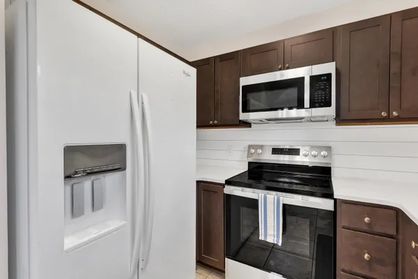a kitchen with stainless steel appliances a stove microwave and sink