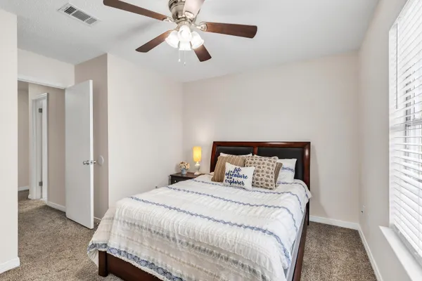 a bedroom with a bed and a large window