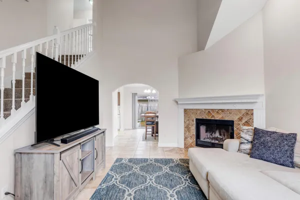 a living room with furniture a flat screen tv and a fireplace