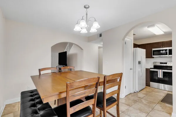 a dining room with wooden floor and chandelier
