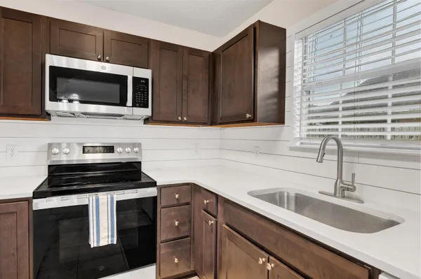 a kitchen with a sink stove and microwave